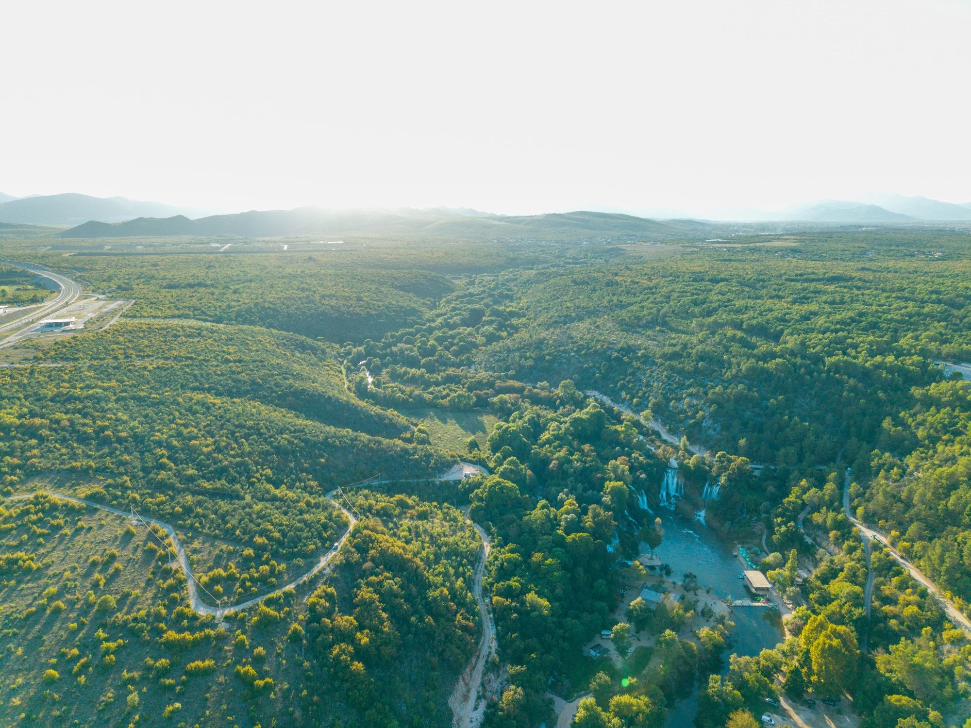 Aerial view of forested waterfall and roads
